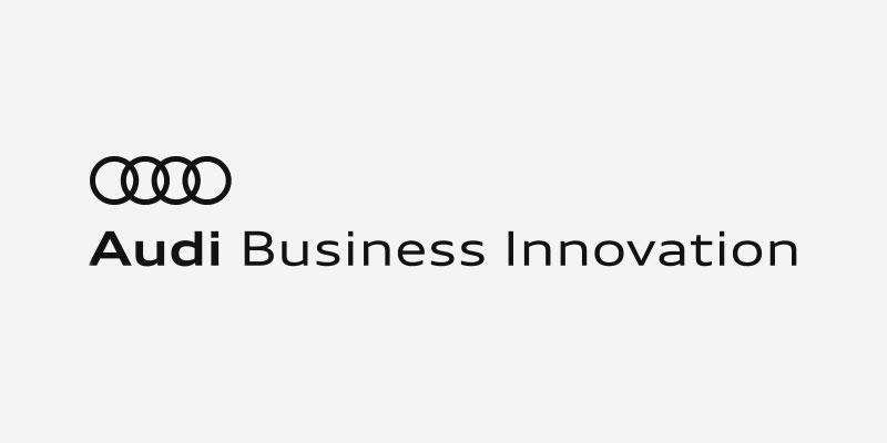Audi Business Innovation logo with four interlinked rings and the text Audi Business Innovation.