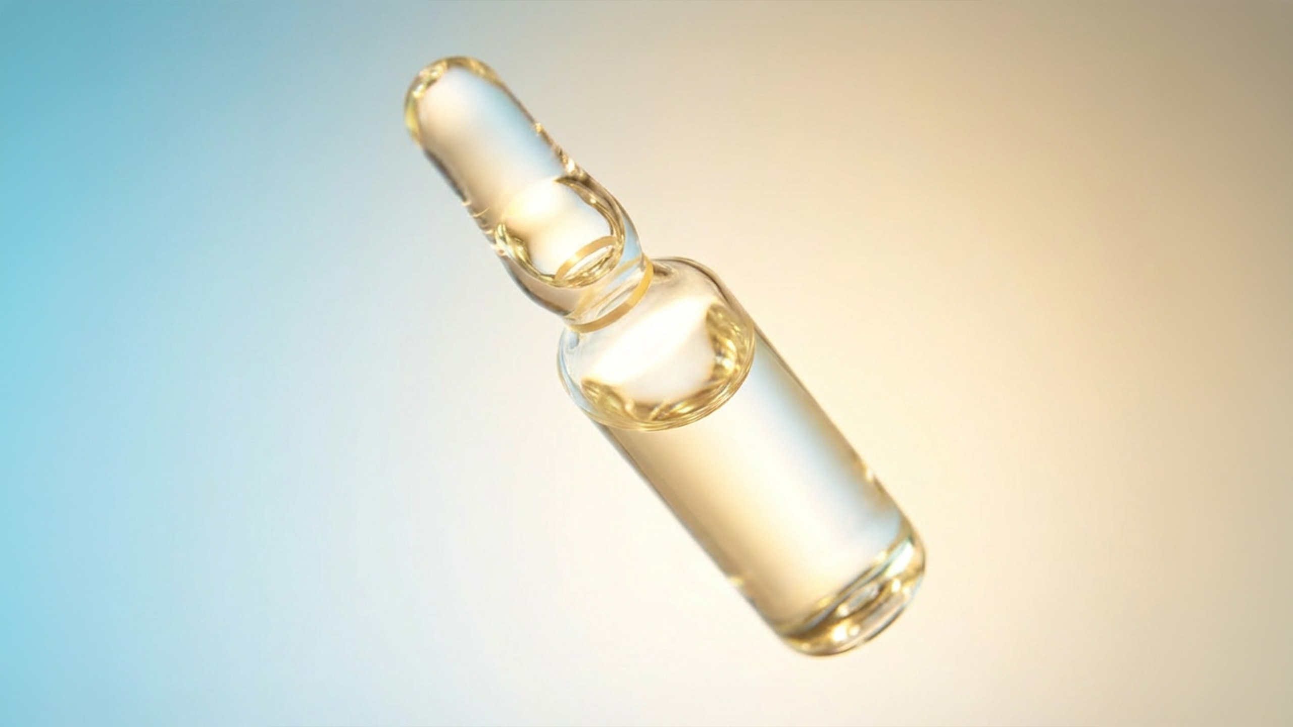 Close-up of a clear glass ampoule filled with a transparent liquid against a gradient blue and beige background.